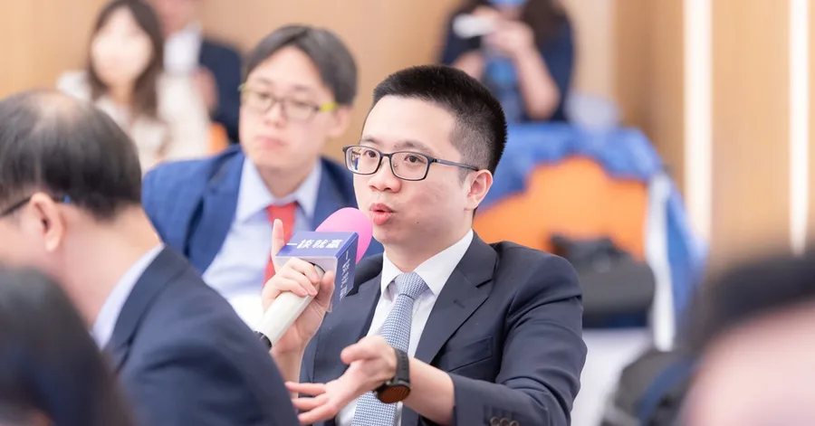 課堂中舉手發言的一刻,一位學員手持印有一談就贏字樣的麥克風正在說話。